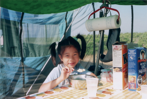The editor (age 8) eating breakfast while camping in Maine