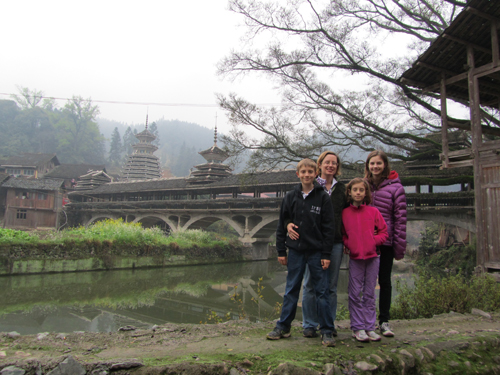 The Spragues in front of a covered wind and rain bridge