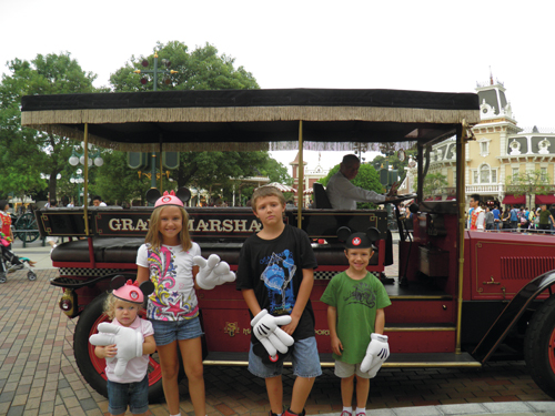 The Barton kids in front of a Grand Marshals parade car