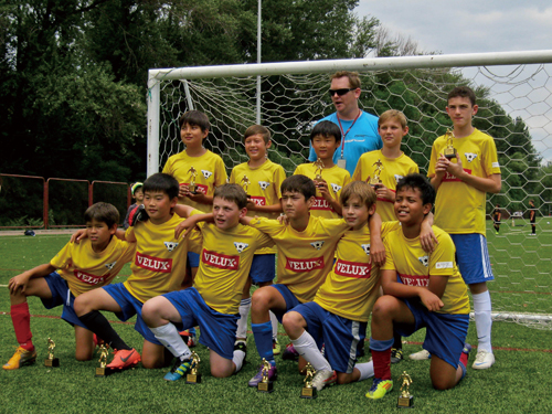 Coach Gary Saunders (blue shirt) and team celebrate a league title at DCB