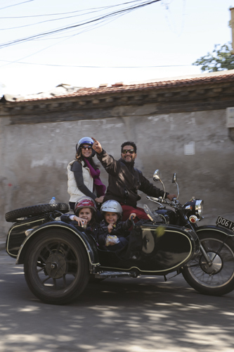 Michelle Comes, Brynn (age 6), Alden (4), and Beijing Sideways Founder Gael Thoreau zoom through a hutong