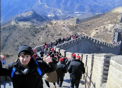 Julio, a ninth grader, stands triumphantly atop the Great Wall of China