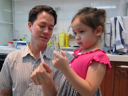 Charlie shows Reina how to test for chlorine levels in drinking water