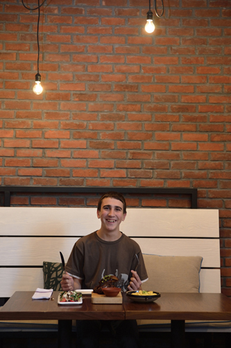 Salomon Lydon-Busquets (13, attends Beijing No. 55 High School) digs into baby spinach and prosciutto salad, Big Smoke Ribs, and truffle mac n' cheese. Photo by the Bloom Family Photography