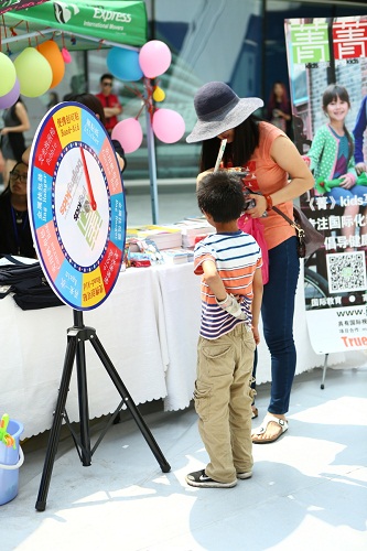 This young visitor spins the beijingkids and JingKids prize wheel