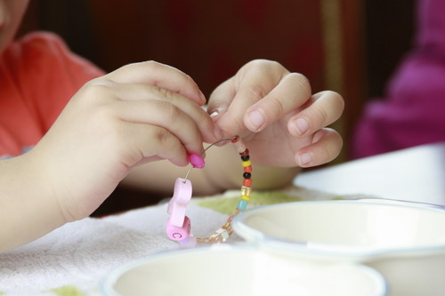 Reina working on her bracelet, photo by Cindy Tarratz