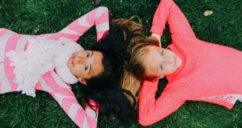 Two teens lying on the grass